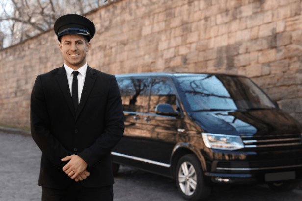 Un chauffeur aidant un couple à charger des bagages dans un véhicule familial de transport.